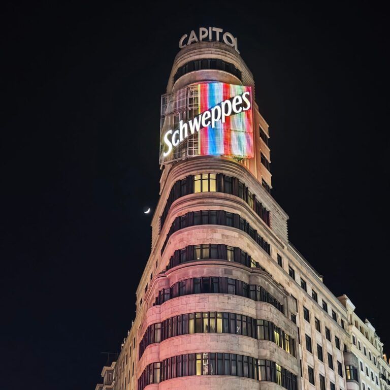 El edificio Carrión (Capitol) de la Gran Vía de Madrid de noche, con el cartel luminoso de Schweppes